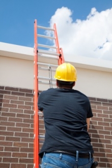 Photo d'un couvreur qui effectue une soumission ou l'entretien d'une toiture résidentielle